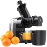 A black juicer machine with a glass of orange juice next to a container and four oranges.
