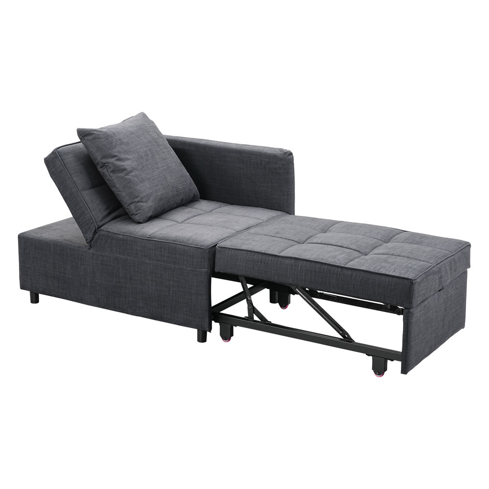 An L-shaped gray sofa bed with a pull-out section and an additional cushion, featuring tufted upholstery and small, dark wheels for mobility.