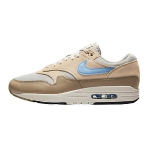 Nike Air Max 1 sneaker featuring a beige and light brown upper with a light blue swoosh, a white midsole, and visible Air unit.