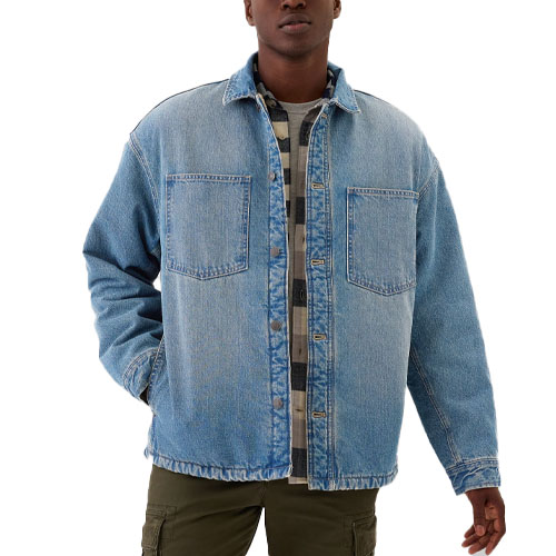 A denim shirt jacket with a button-up front and two chest pockets, featuring a sherpa lining for added warmth. It is styled over a plaid shirt, and paired with olive green pants.