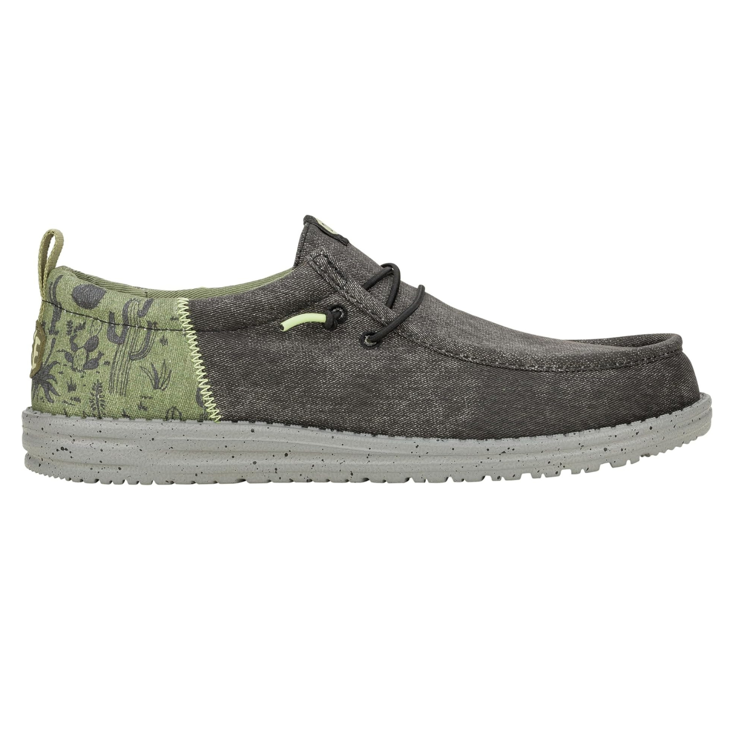 Hey Dude Wally Funk Desert Shoes feature a blend of dark gray and light green colors with a desert-themed pattern on the heel. They have a lightweight design with a speckled sole and easy slip-on style.