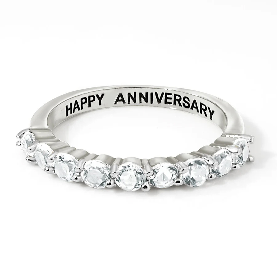 Sterling Silver & Topaz Eternity Band featuring a row of sparkling topaz gems set in a sleek silver band with \“HAPPY ANNIVERSARY\“ engraved on the inside.