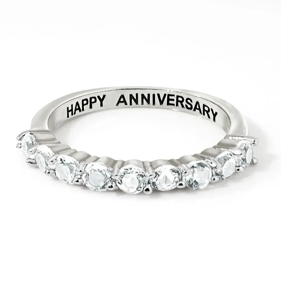 Sterling Silver & Topaz Eternity Band featuring a row of sparkling topaz gems set in a sleek silver band with \“HAPPY ANNIVERSARY\“ engraved on the inside.