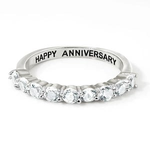 Sterling Silver & Topaz Eternity Band featuring a row of sparkling topaz gems set in a sleek silver band with \“HAPPY ANNIVERSARY\“ engraved on the inside.