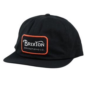A black baseball cap featuring a \“Brixton Manufacturing Co.\“ logo patch with an orange border on the front.