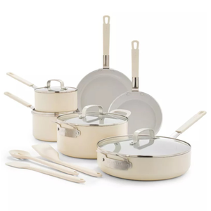 A cream-colored cookware set featuring two fry pans, a sauté pan, two saucepans, and two lids, accompanied by three kitchen utensils.