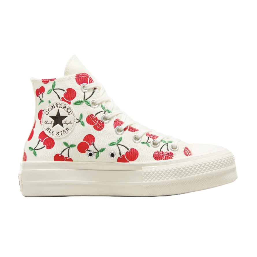 A white Chuck Taylor All Star high-top shoe with platform soles, featuring a colorful cherry pattern and the classic Converse logo on the side.