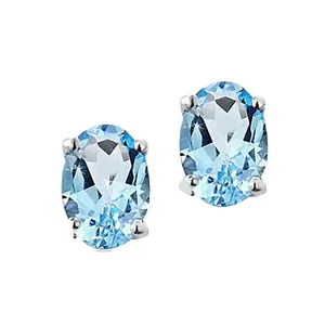 A pair of oval-cut blue gemstone stud earrings set in a four-prong silver setting.