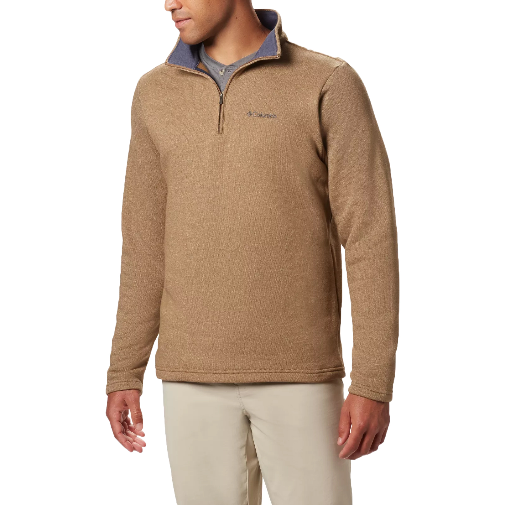 A man wears a tan Columbia Great Hart Quarter-Zip Pullover featuring a contrasting gray inner collar, embroidered logo on the chest, and long sleeves. It's paired with light-colored pants and is designed for casual or outdoor wear.