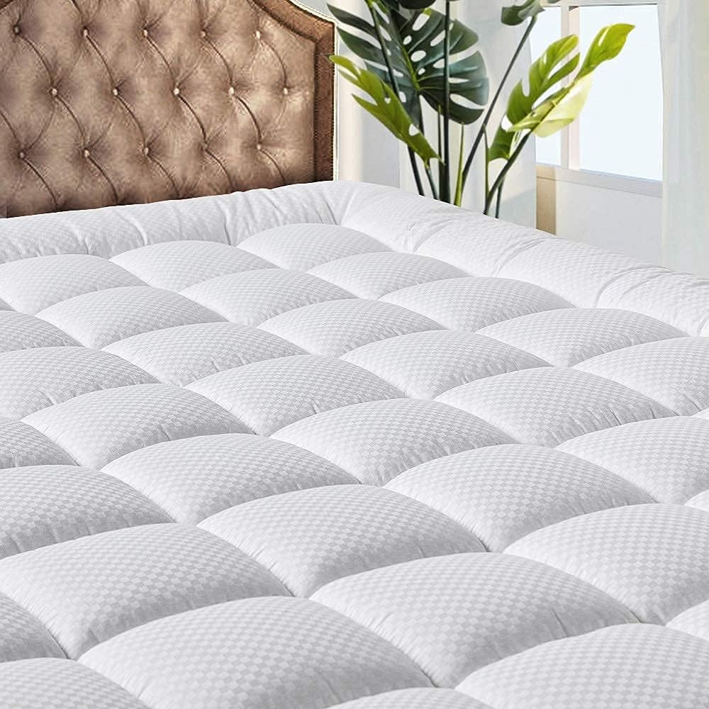 Queen Quilted Cooling Mattress Pad with a plush, checker-patterned surface designed for comfort and breathability, featuring a cushioned, quilted design for added support on a bed.