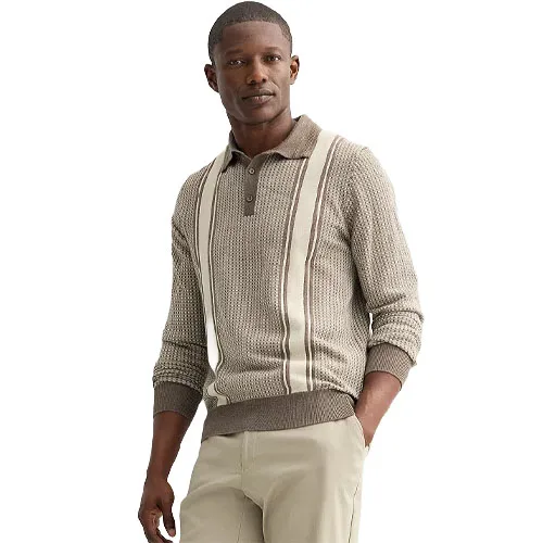 A man wearing a knitted, long-sleeve polo sweater with vertical cream stripes over a beige base, paired with light-colored pants.