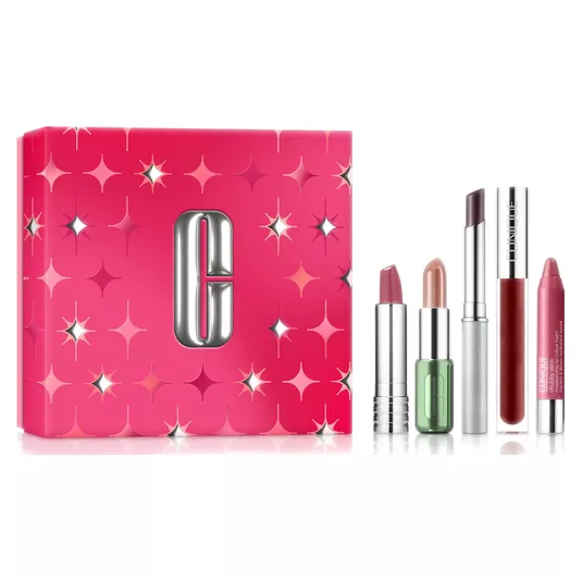 A Clinique gift set featuring four lip products in various shades: two lipsticks, a chubby lip balm, and a high-shine gloss, alongside a pink box decorated with silver stars.