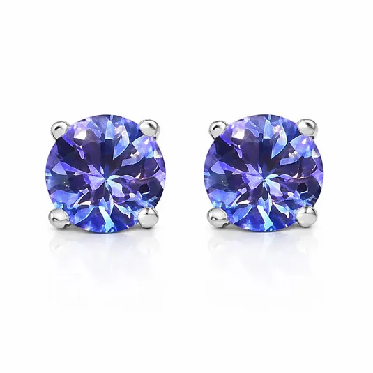 Pair of round-cut, blue-purple gemstone stud earrings set in silver prongs, reflecting light with a vibrant sparkle.