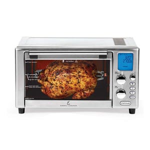 Emeril Lagasse Air Fryer Oven, refurbished model, features a digital display and multiple control knobs. It includes a rotisserie function, shown cooking a whole chicken. The appliance combines air frying, baking, and roasting capabilities.