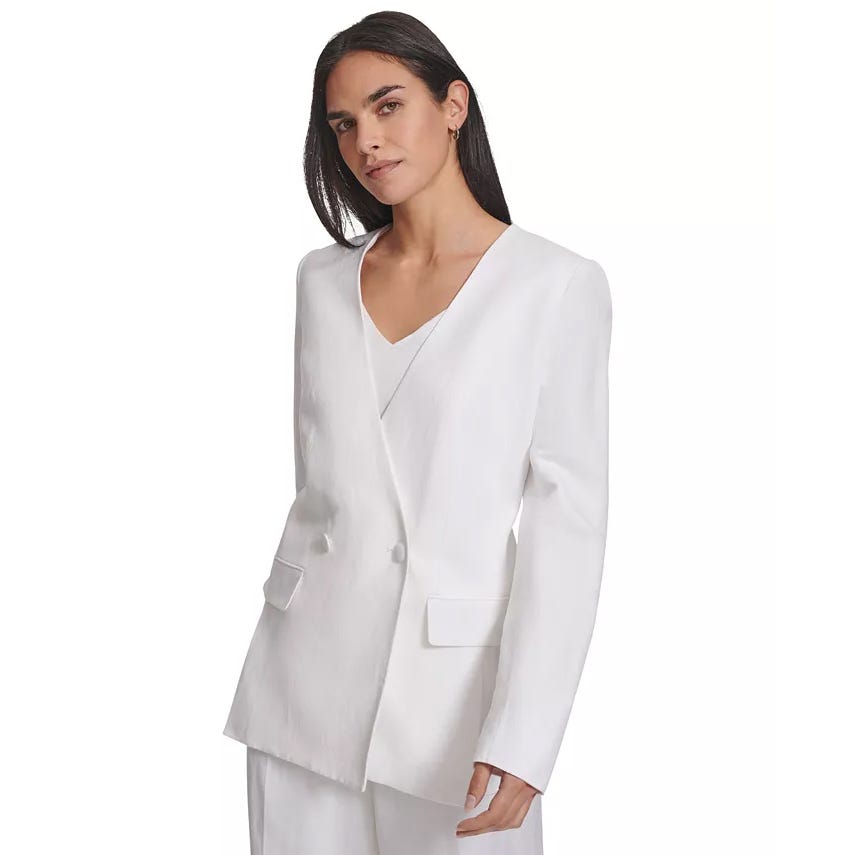 A woman is wearing a white blazer with a V-neckline and front pockets.
