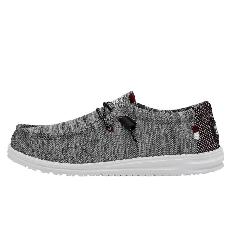 A grey knit fabric shoe with a white sole, featuring lacing details and contrasting patterns near the heel.
