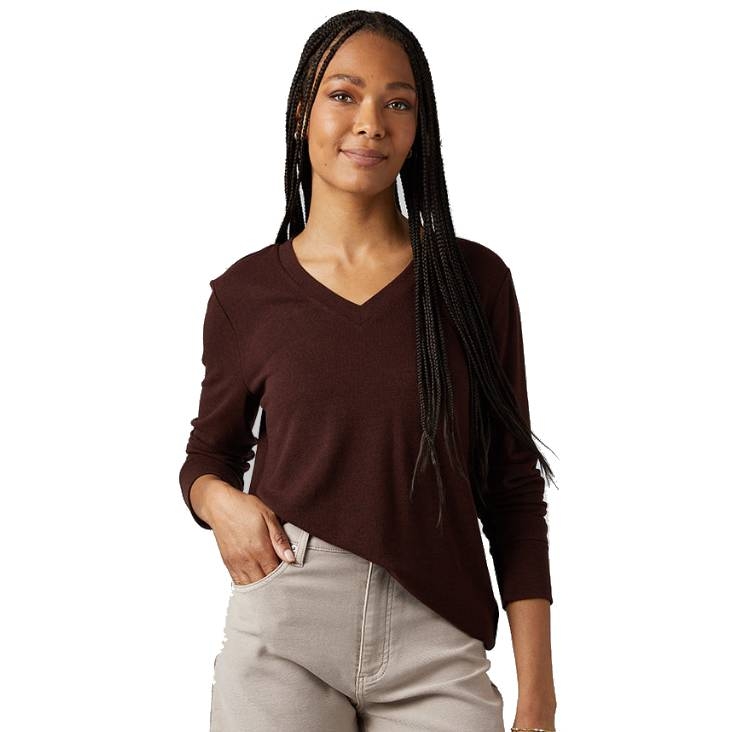 A person wearing a long-sleeve brown V-neck top paired with light-colored, high-waisted pants.