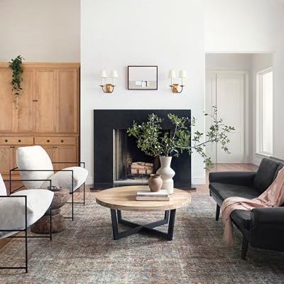 A textured area rug with a blend of muted blue, pink, and beige tones, featuring a distressed pattern that contributes to a vintage aesthetic.