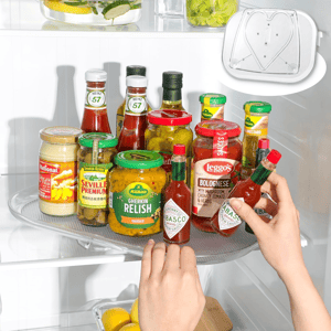 Various condiments, including Tabasco sauce, Leggo's Bolognese, Heinz ketchup, and Kühne gherkin relish, are arranged on a fridge tray next to lemons and herbs.
