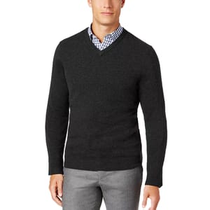 A men's dark gray V-neck cashmere sweater worn over a checkered button-up shirt. The outfit is paired with gray trousers for a classic, formal look.