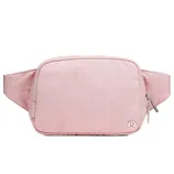 Pink belt bag with a zip closure and the Lululemon logo on the lower right corner.