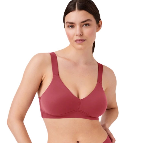 A woman is wearing a seamless, unlined bralette in a deep rose color with adjustable straps and a scoop neckline.