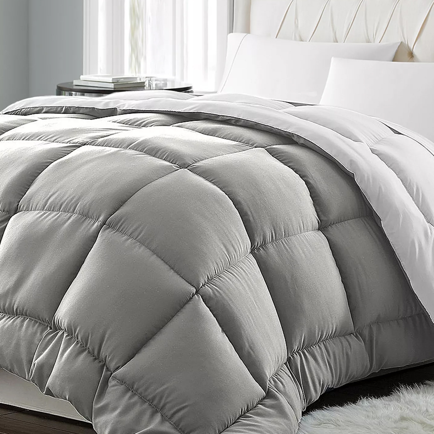 A gray, quilted comforter with a plush, diamond-pattern design is placed on a bed with white pillows and sheets.
