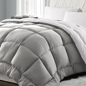 A gray, quilted comforter with a plush, diamond-pattern design is placed on a bed with white pillows and sheets.