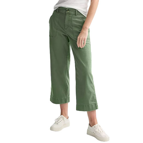 A person is wearing green wide-leg cropped pants with large front pockets, paired with a white shirt and white sneakers.