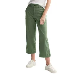 A person is wearing green wide-leg cropped pants with large front pockets, paired with a white shirt and white sneakers.