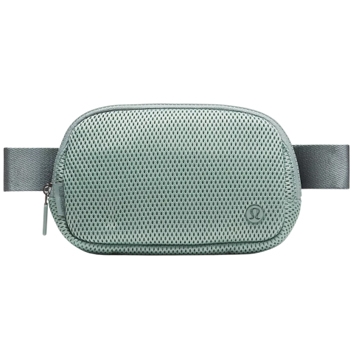 A compact, textured crossbody bag with a front zipper and adjustable strap, featuring a subtle logo on the corner.