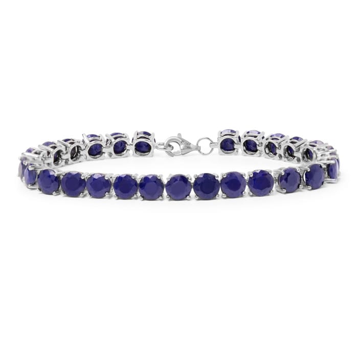 A silver tennis bracelet featuring deep blue gemstones, arranged in a line with a clasp for fastening.