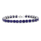 A silver tennis bracelet featuring deep blue gemstones, arranged in a line with a clasp for fastening.
