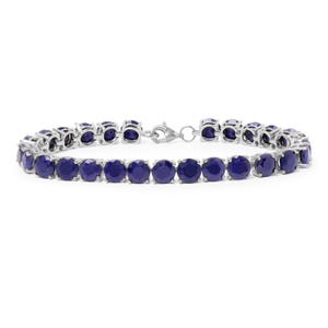 A silver tennis bracelet featuring deep blue gemstones, arranged in a line with a clasp for fastening.
