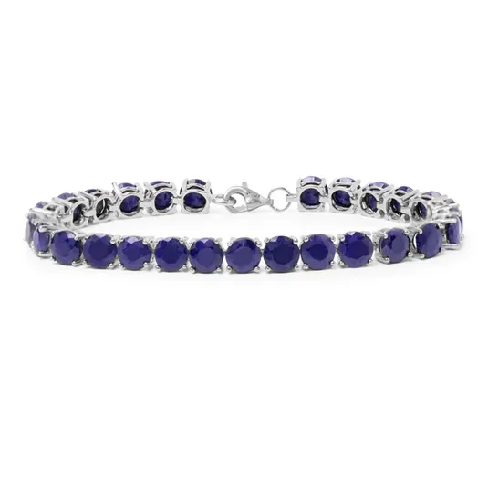 A silver tennis bracelet featuring deep blue gemstones, arranged in a line with a clasp for fastening.