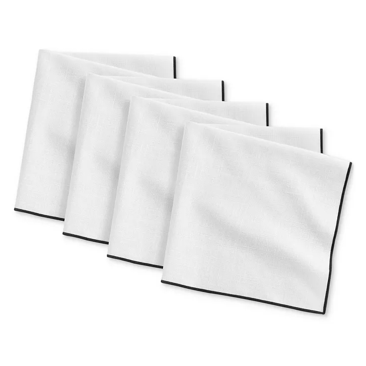 White cloth napkins with black trim, arranged slightly overlapping each other.