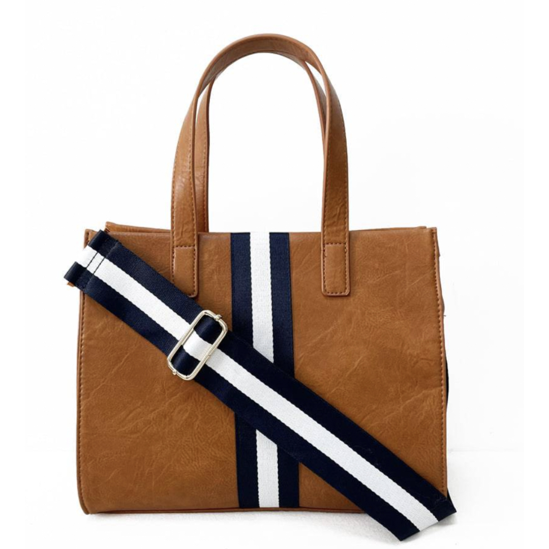 A brown 12\“ tote bag features dual handles and a detachable navy and white striped shoulder strap for versatile carrying.