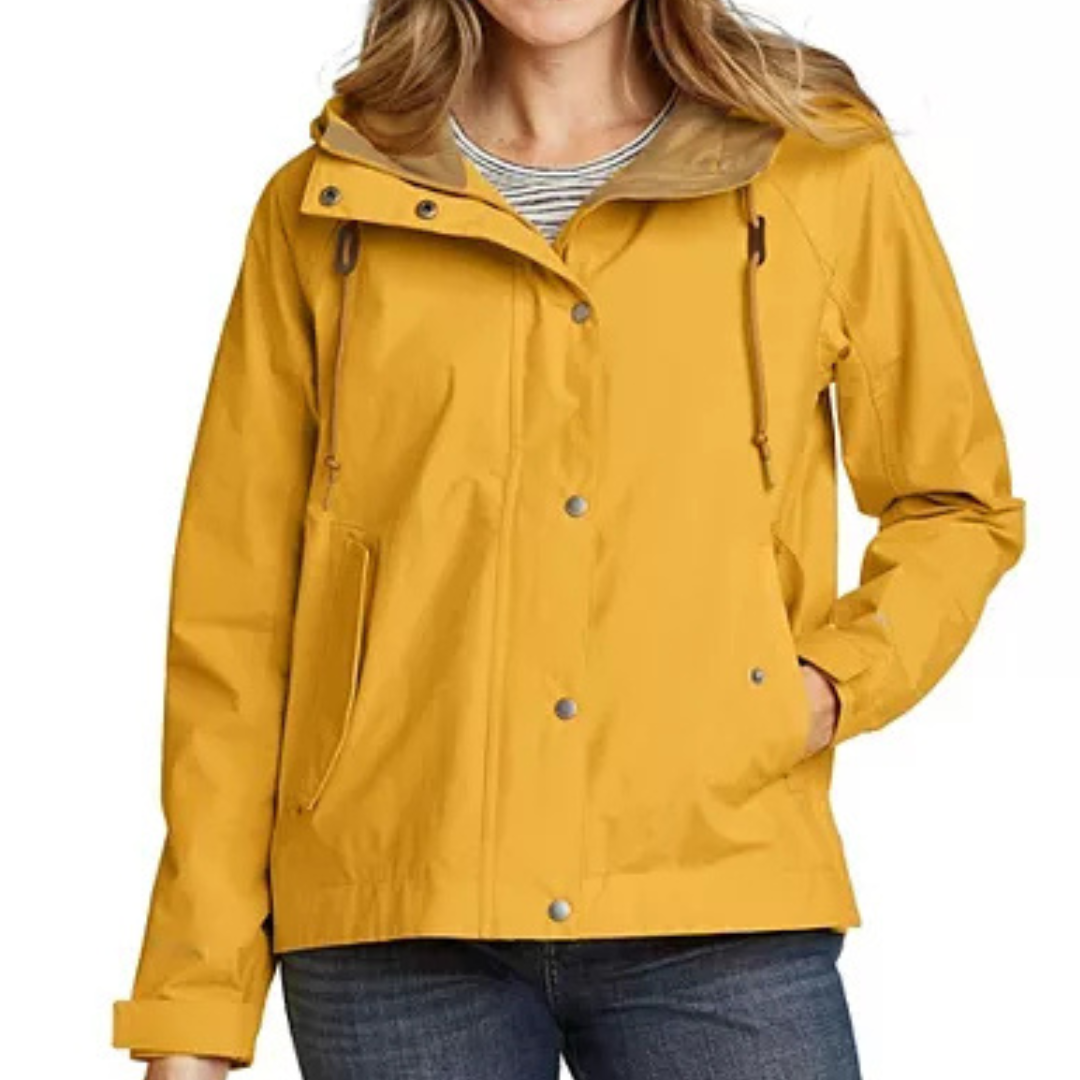 Yellow hooded rain jacket with snap buttons and adjustable drawstrings, worn over a striped shirt, paired with jeans.