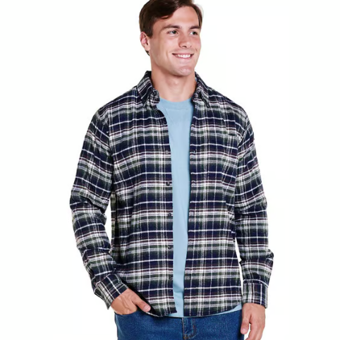 A man wearing a navy, white, and green plaid flannel shirt over a light blue t-shirt, paired with blue jeans.