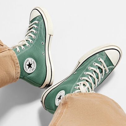 A pair of green high-top canvas sneakers with white laces and rubber soles.