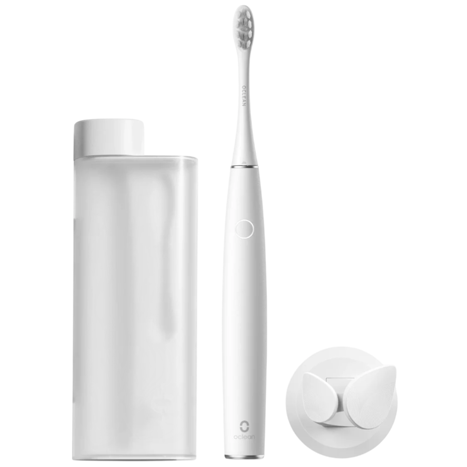 Electric toothbrush with a sleek design, shown alongside a stand and a travel case, in a minimalist white theme.