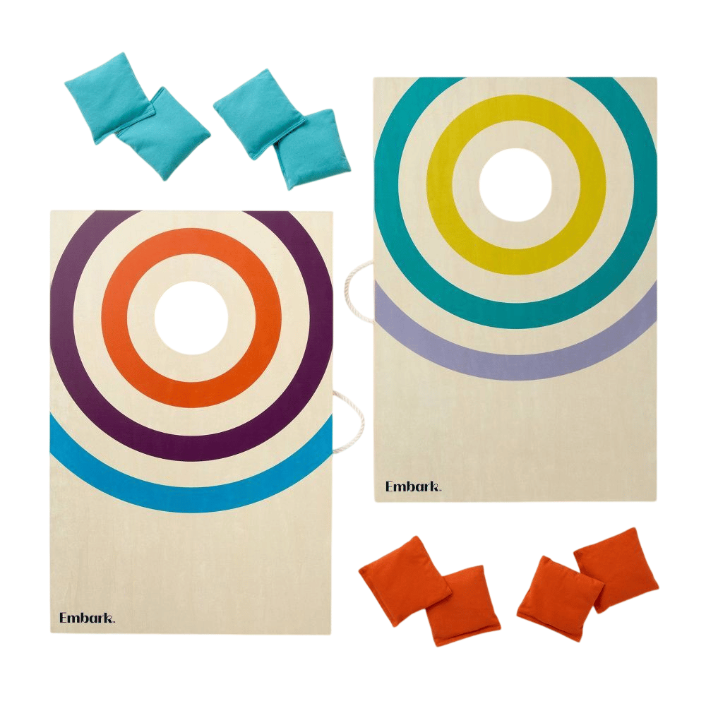 A set of two wooden cornhole boards with colorful concentric circle designs and a set of bean bags in blue and red.