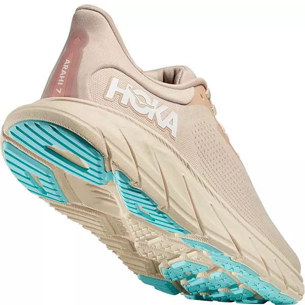 Hoka Arahi 7 Running Shoes feature a beige color with a cushioned, supportive midsole and a breathable upper. The sole has blue accents for traction, designed for stability and comfort.