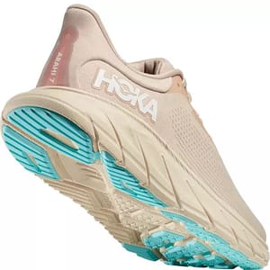 Hoka Arahi 7 Running Shoes feature a beige color with a cushioned, supportive midsole and a breathable upper. The sole has blue accents for traction, designed for stability and comfort.