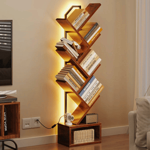 A modern wooden bookshelf with a geometric design features diagonal shelves, illuminated by LED lighting. It's adorned with books and has a lower compartment containing a wicker basket and a small speaker.