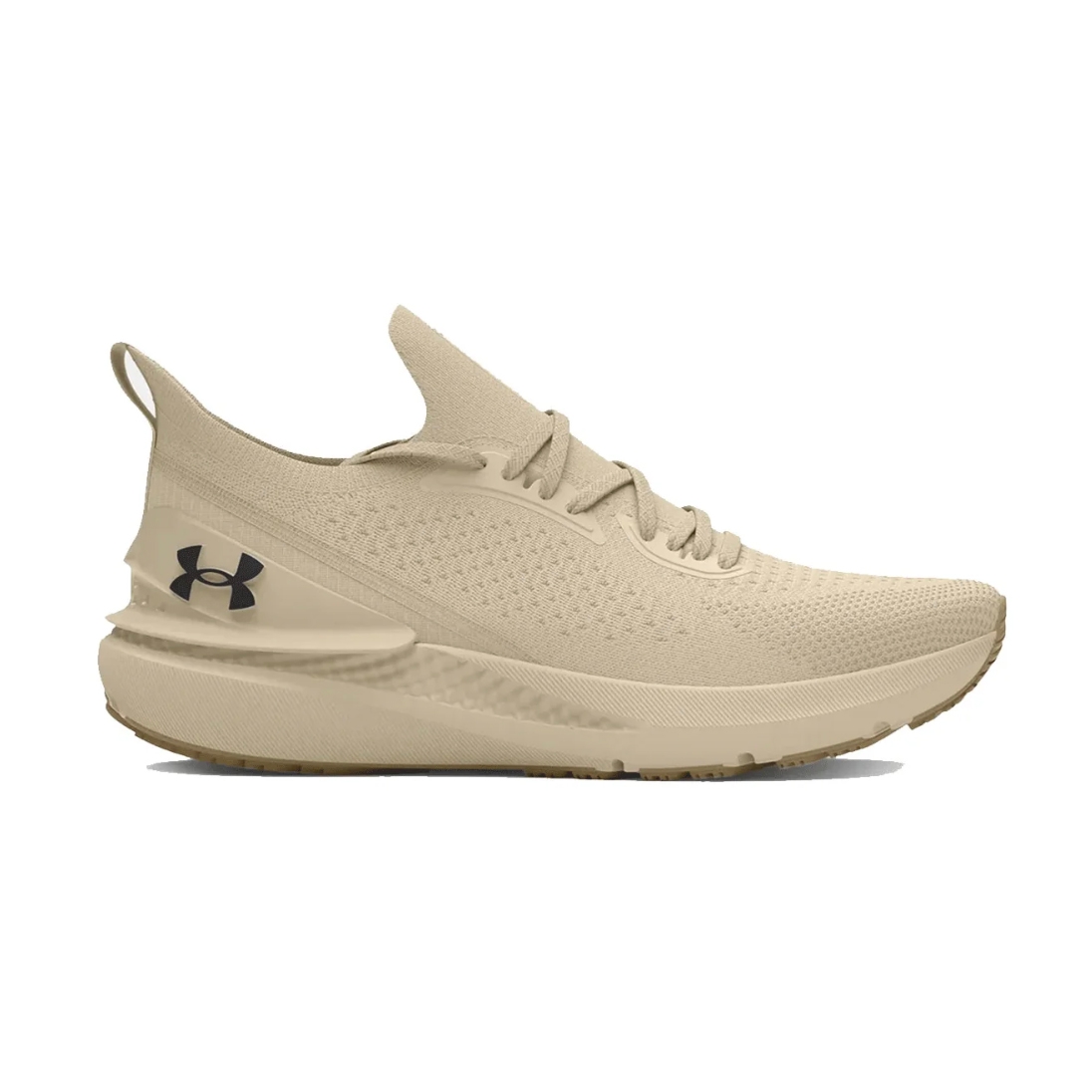 Under Armour Charged shoes feature a streamlined, beige knit design with a pull tab at the heel and a black logo on the side. They have a cushioned sole that offers comfort and support for running or casual wear.