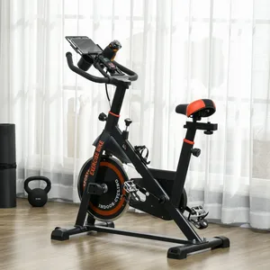 Indoor exercise bike with adjustable seat and handlebars, featuring a flywheel marked \“EXERCISE BIKE\“ and \“INDOOR CYCLING,\“ a tablet holder, and a water bottle holder. Nearby are a yoga mat and a kettlebell.