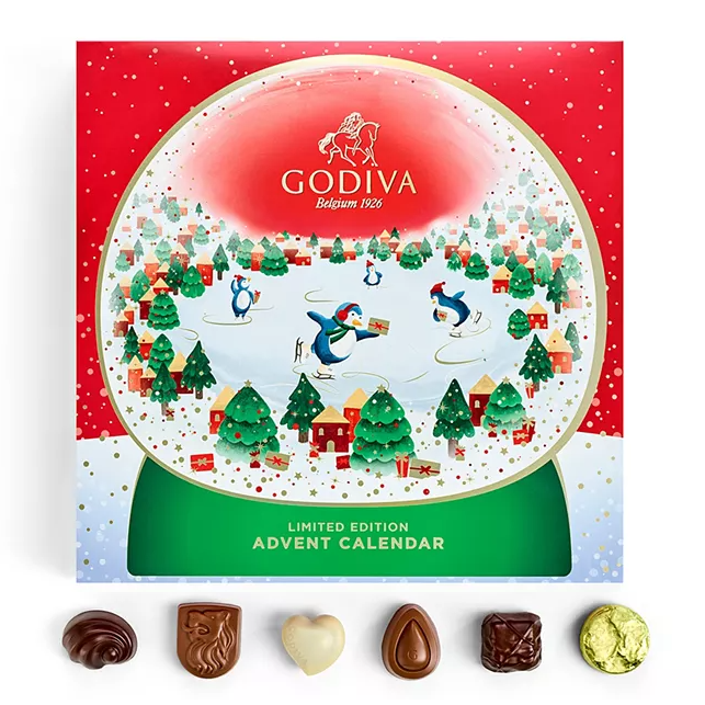 A Godiva Limited Edition Advent Calendar with a festive design and several assorted chocolates displayed in front.