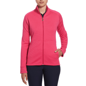 A woman is wearing a pink zip-up Callaway fleece golf jacket with a textured design, featuring a high collar and long sleeves. She is also wearing dark trousers.