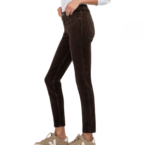 KUT from the Kloth corduroy pants are brown, high-waisted, and feature a slim fit. They end at the ankle and are paired with beige sneakers in the image shown.
